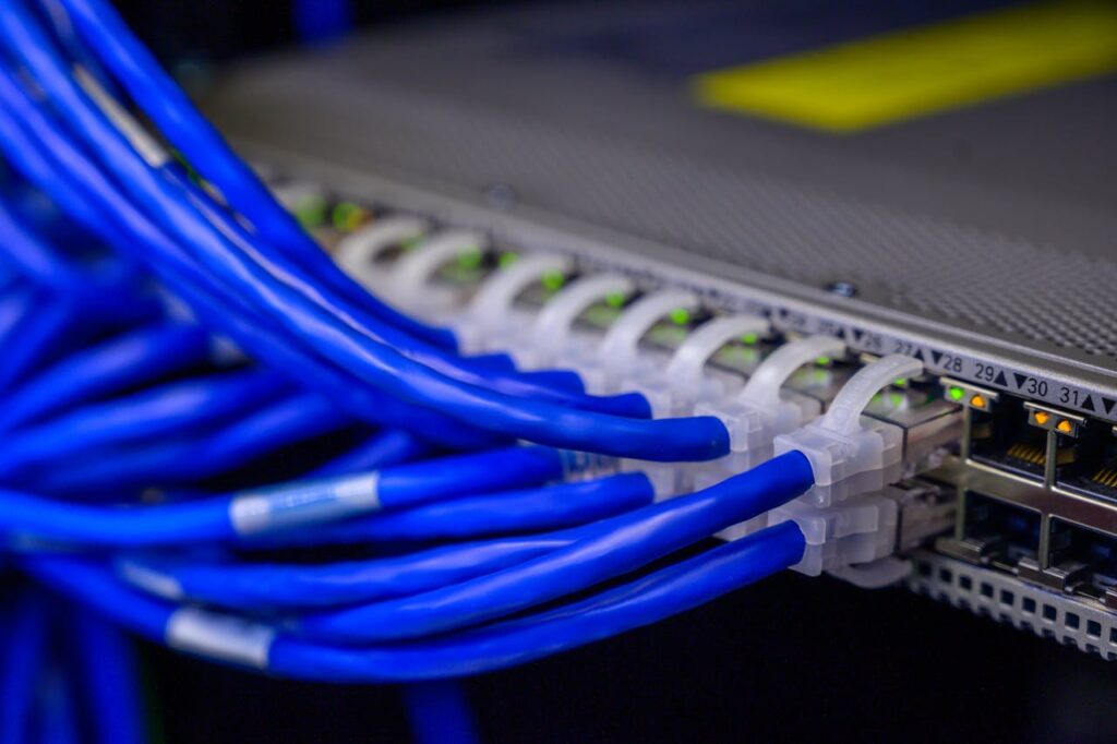 stock_landing2 Detailed view of blue ethernet cables connected to a network switch in a data center.